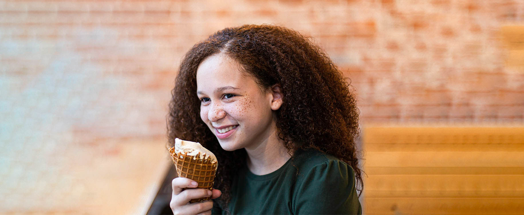 young girl eating ice cream in a shop.